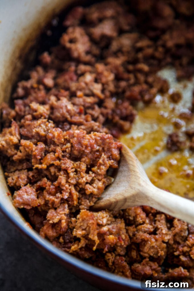 Crumbled Mexican chorizo cooking in a skillet, sizzling and browning