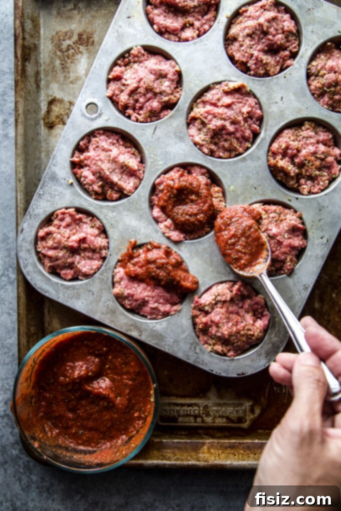 Spiced Beef & Feta Meatloaf Muffins 5 A serving of Spiced Beef Meatloaf Muffins with Feta on a plate, garnished with fresh herbs.