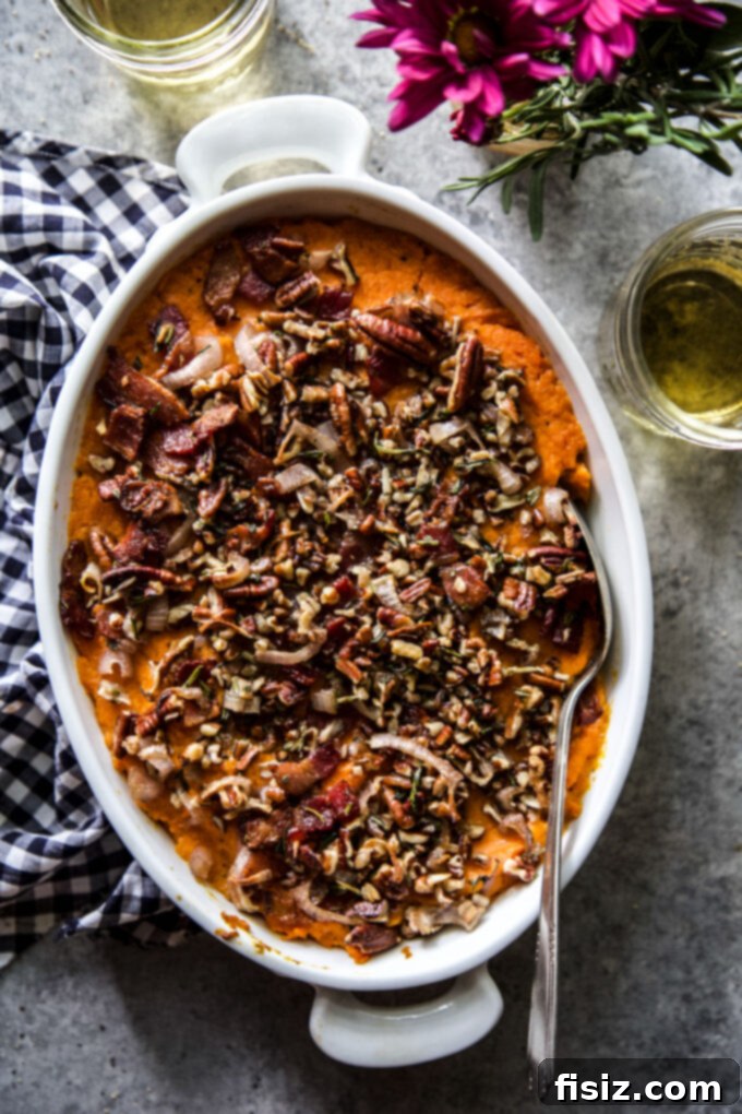 Herbed Sweet Potato Casserole 2 Golden-brown Savory Sweet Potato Casserole in a baking dish, garnished with fresh rosemary. The perfect holiday side dish.