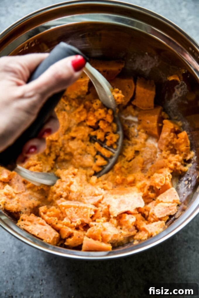 Mashing sweet potatoes in a bowl