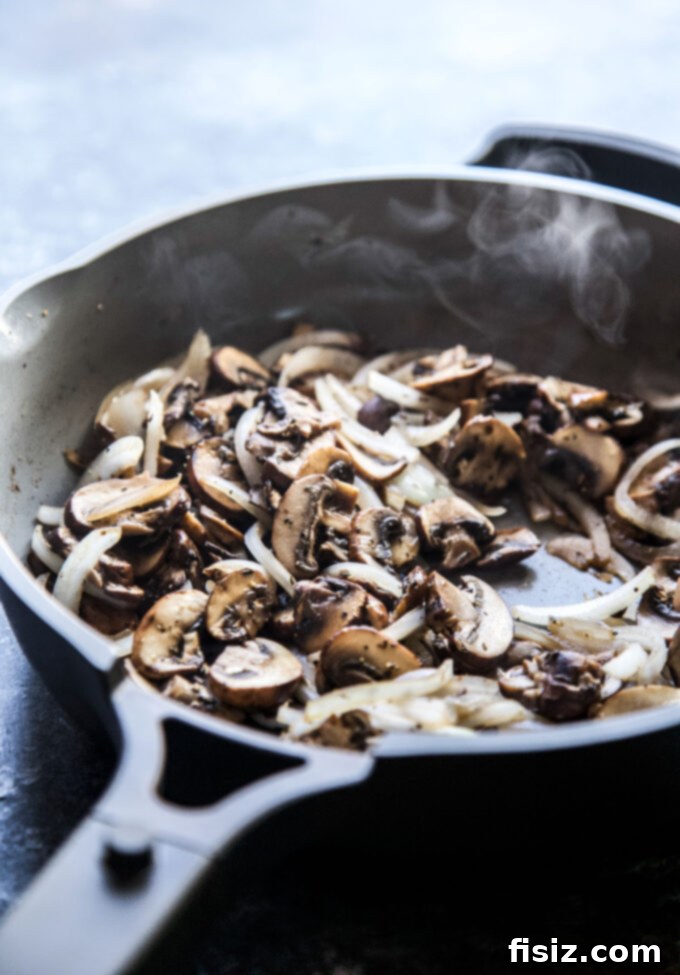 Creamy Burrata Mushroom Sheet Pan Pizza 4 Sautéing baby bella mushrooms in a skillet until perfectly caramelized.