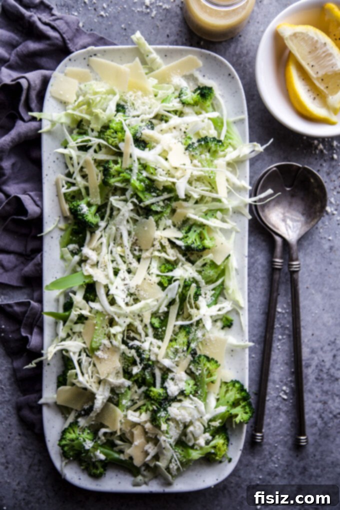 Crisp Broccoli Caesar 6 A close-up of the finished Broccoli Caesar Salad, garnished with extra Parmesan cheese and black pepper, showcasing its fresh appeal.
