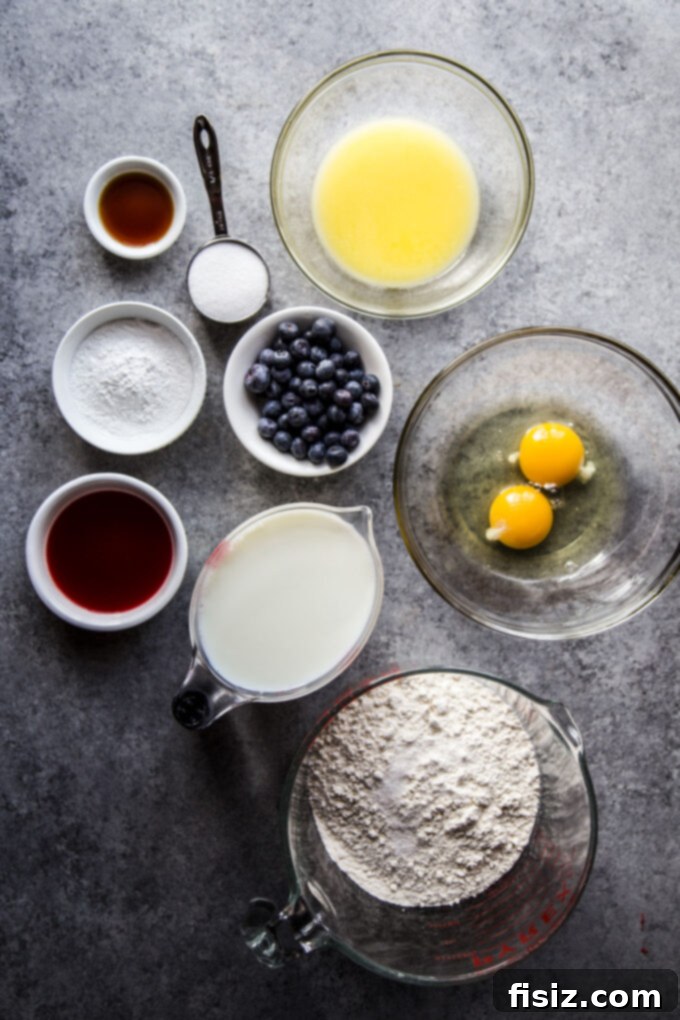 Uncooked pancake batter with blueberries and blood orange slices spread evenly on a baking sheet, ready for the oven.