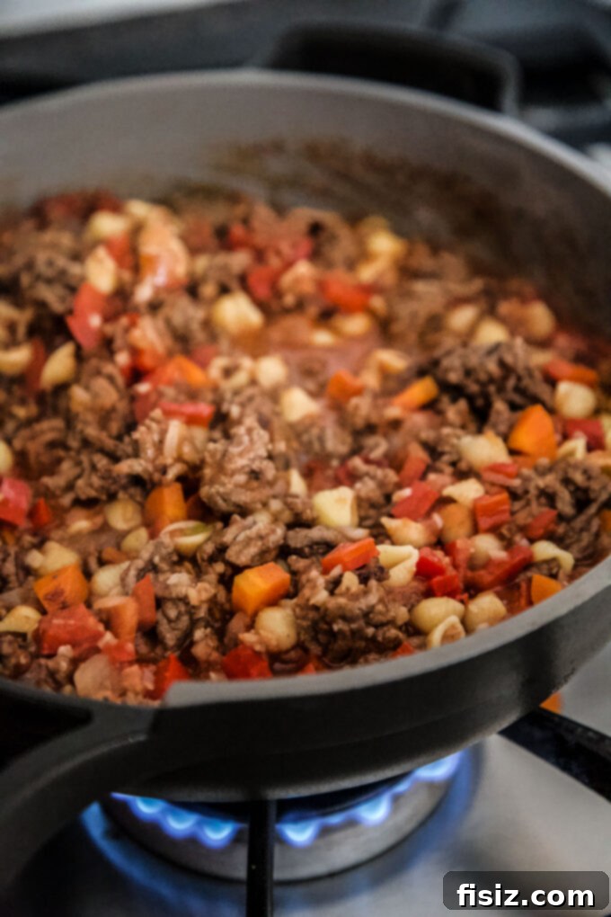 Homestyle Sloppy Joe Turkey Bake 5 Turkey Sloppy Joe ingredients cooking in a skillet on the stove.