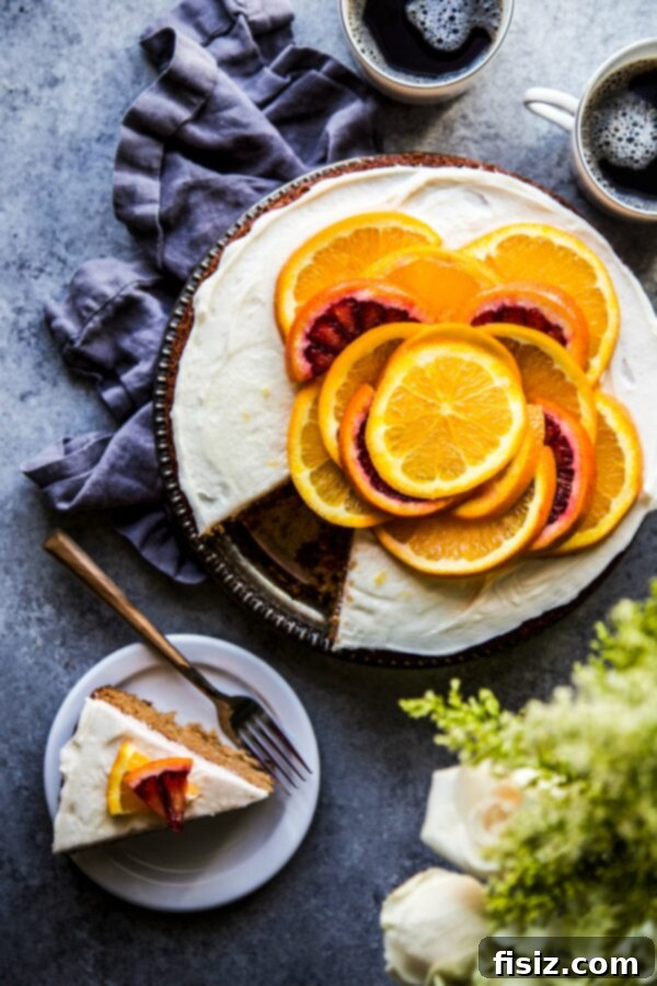 A slice of elegant Honey Cake with Citrus Vanilla Frosting, garnished with fresh fruit