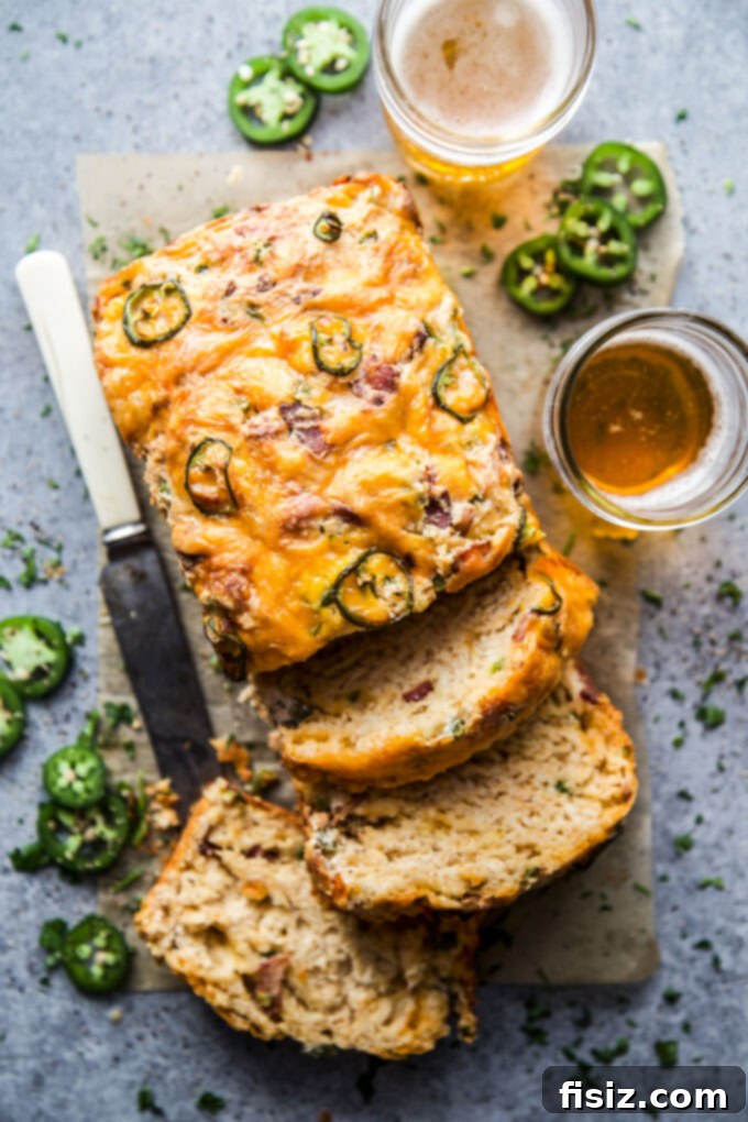 Quick Beer Cheese Bread 2 Delicious Easy Beer Cheese Bread with melted cheese and crispy bacon visible on top, served on a cutting board, ready to be sliced.