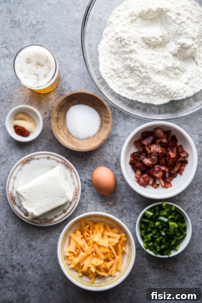 Quick Beer Cheese Bread 4 A collection of fresh, high-quality ingredients laid out on a table, including flour, a bottle of beer, eggs, various cheeses, cooked bacon, and fresh jalapenos, all ready for making delicious beer cheese bread.