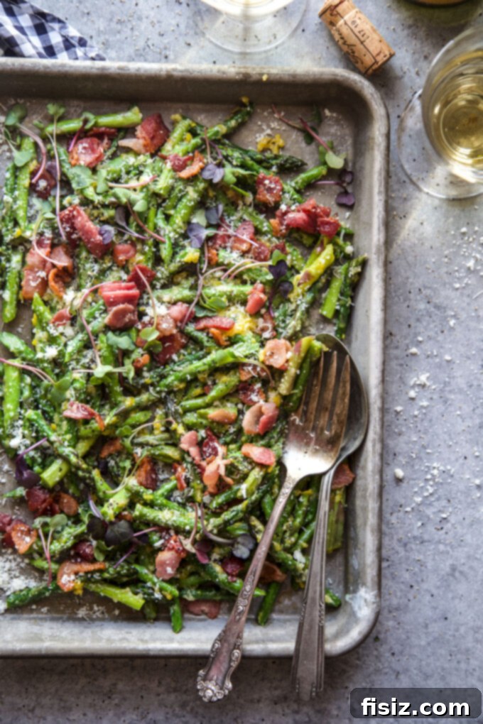 Spring Asparagus Carbonara 7 A serving bowl filled with a generous portion of freshly made Easy Asparagus Carbonara, garnished with extra Parmesan and black pepper.