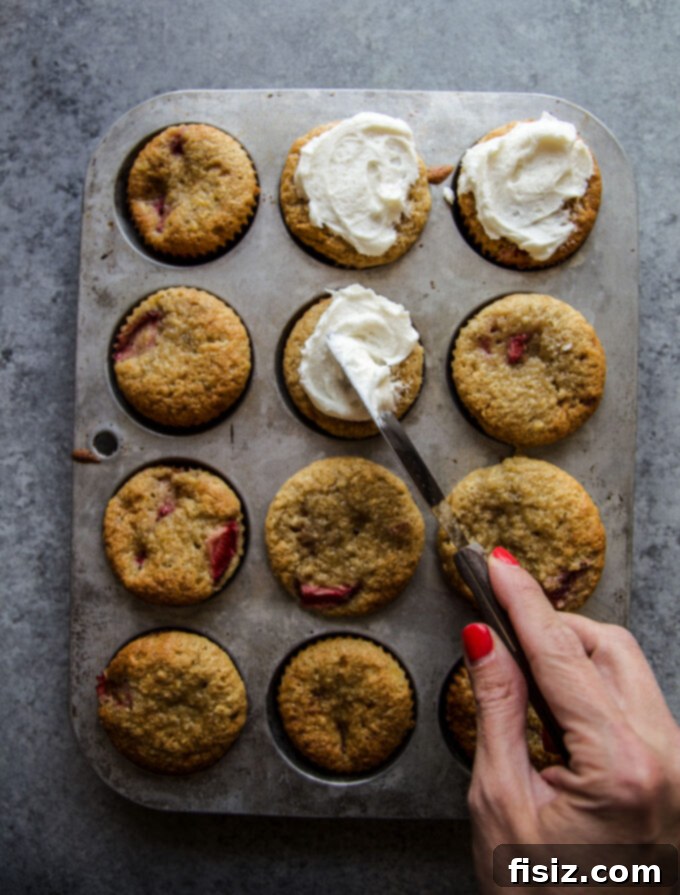Close-up of a single, perfectly frosted Strawberry Banana Bread Muffin