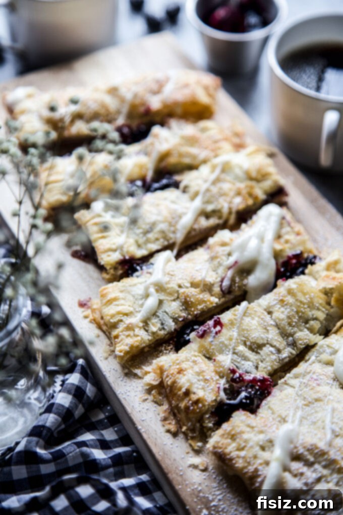 Flaky Blueberry Lemon Pastry 3 Two slices of Blueberry and Meyer Lemon Puffed Pastry Tart on a white plate, ready to be served for breakfast or dessert.