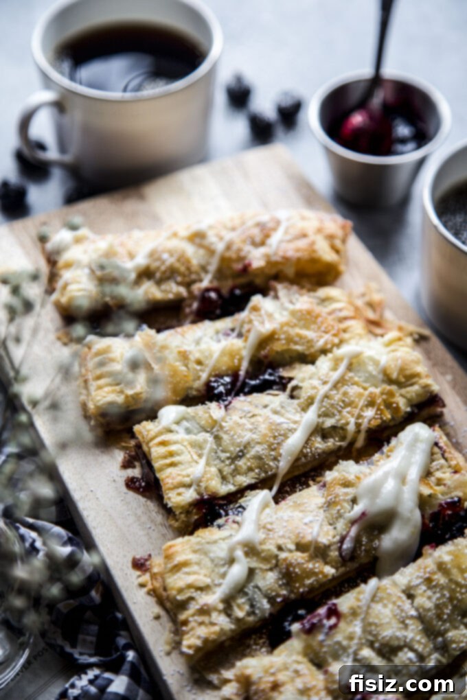 Flaky Blueberry Lemon Pastry 9 The Blueberry and Meyer Lemon Puffed Pastry Tart served on a wooden board, garnished with fresh blueberries and lemon slices.