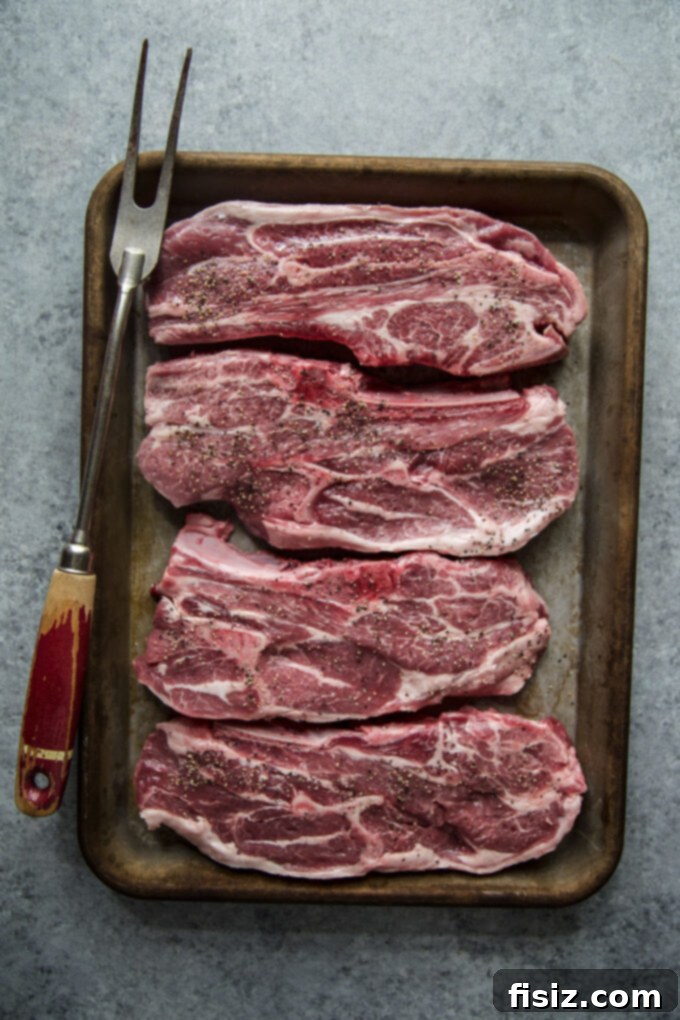 Grilled American Lamb Shoulder Chops, Greek-Style 7 Grilled American Lamb Shoulder Chops being removed from the grill with tongs.