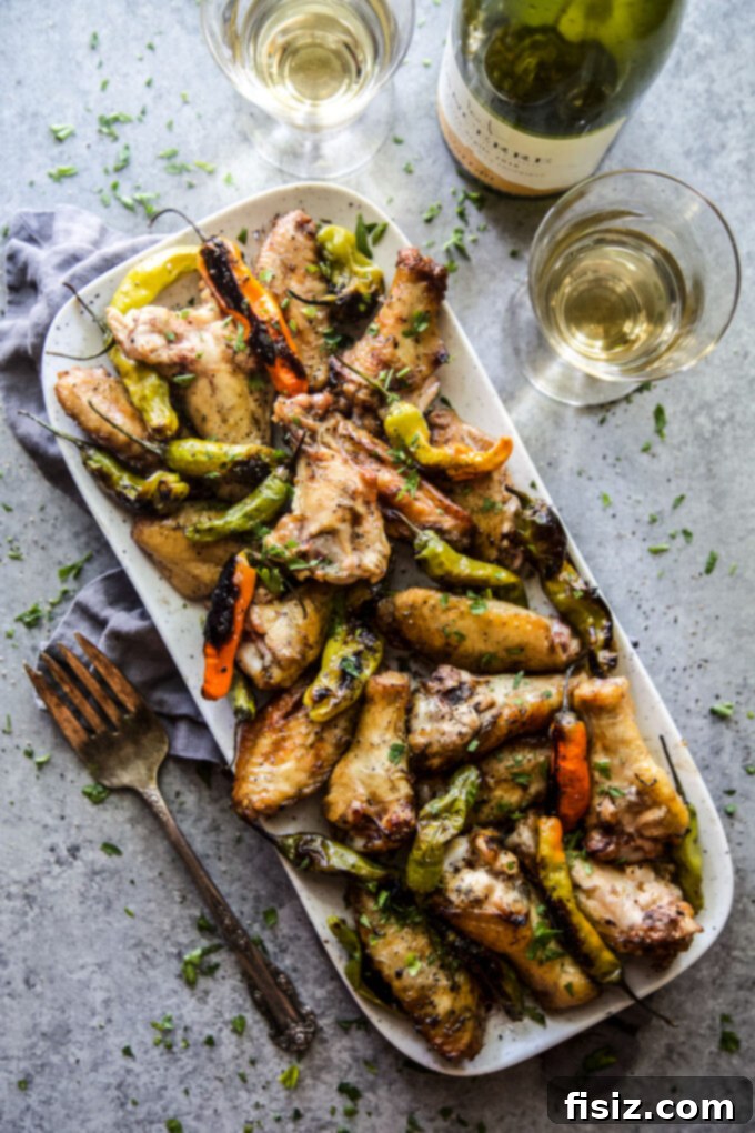 Tangy Lemon-Garlic Wings & Charred Shishitos 2 Lemon Garlic Grilled Chicken Wings with Shishito Peppers on a plate, ready to be served