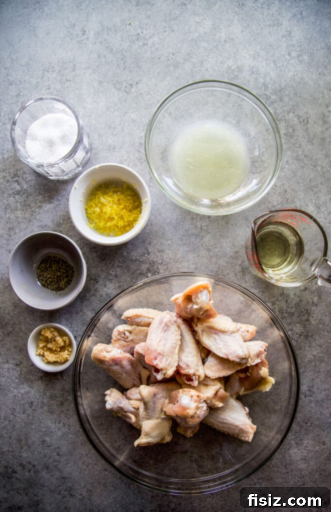 Tangy Lemon-Garlic Wings & Charred Shishitos 4 Ingredients laid out for Lemon Garlic Grilled Chicken Wings with Shishito Peppers: garlic cloves, lemons, olive oil, chicken wings, shishito peppers