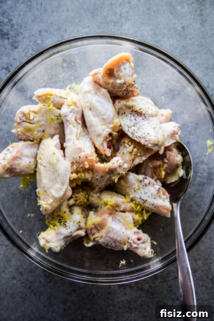 Tangy Lemon-Garlic Wings & Charred Shishitos 5 Chicken wings marinating in a bowl with lemon garlic marinade