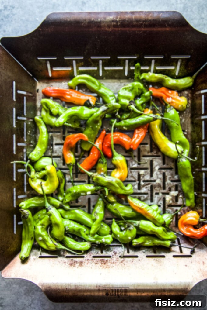 Tangy Lemon-Garlic Wings & Charred Shishitos 6 Shishito peppers in a grilling basket on the grill