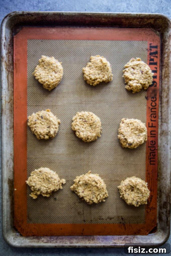 Warm Maple Drizzled Pumpkin Oat Cookies 8 Pre-baked pumpkin oatmeal cookies cooling on a baking sheet before glazing
