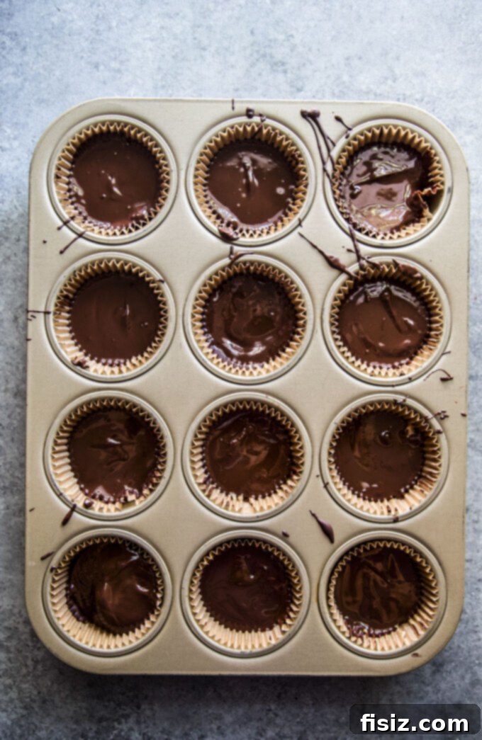 Wicked Good Halloween Dark Chocolate Peanut Butter Cups 7 A collection of Homemade Dark Chocolate Peanut Butter Cups, each uniquely adorned with Halloween sprinkles and candy eyeballs.