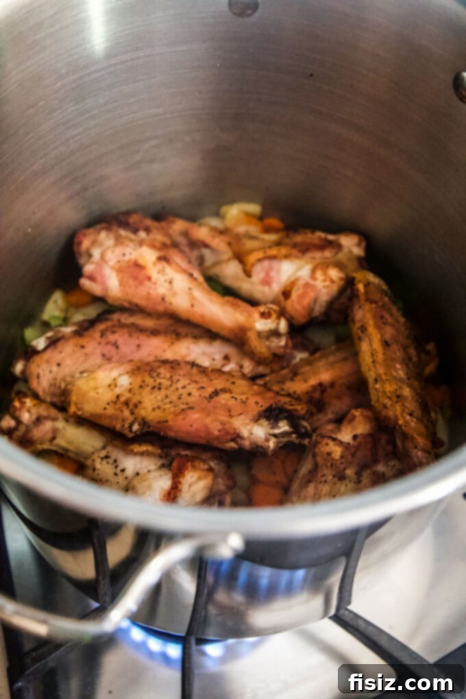Simple Homemade Turkey Stock 7 Roasted turkey wings added to vegetables in a stock pot