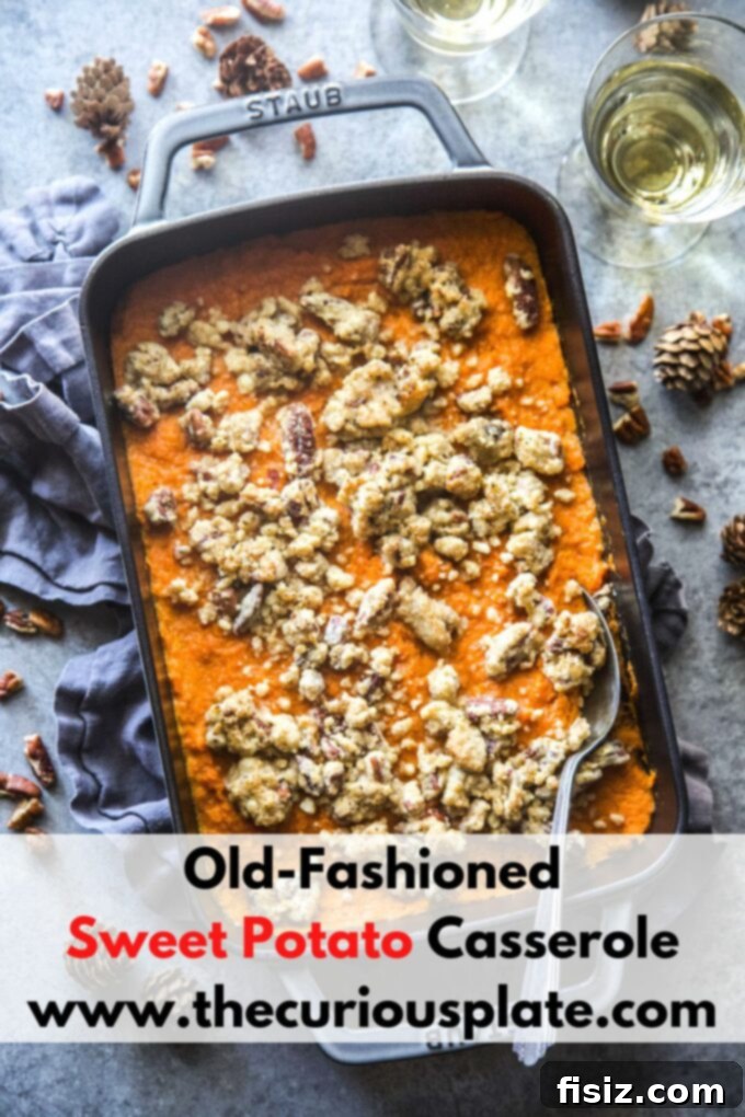 A large baking dish of old-fashioned sweet potato casserole with a golden brown pecan streusel topping, ready for serving.