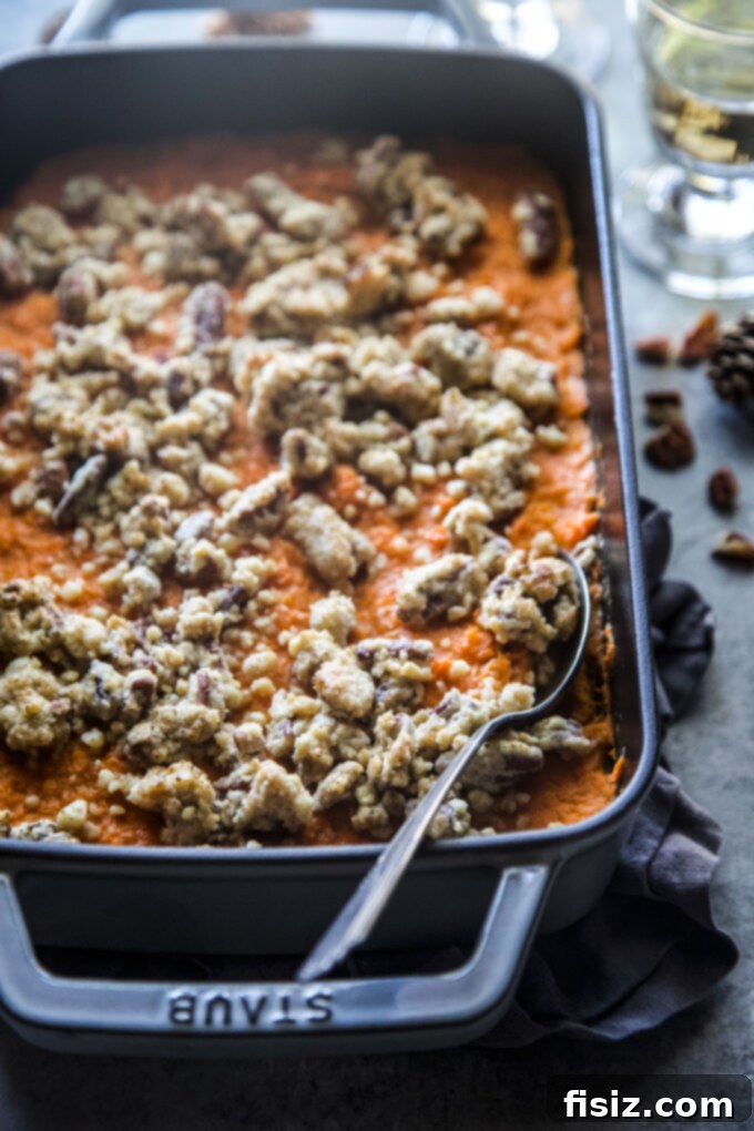 Close-up of old-fashioned sweet potato casserole with a golden pecan streusel topping, ready for serving.