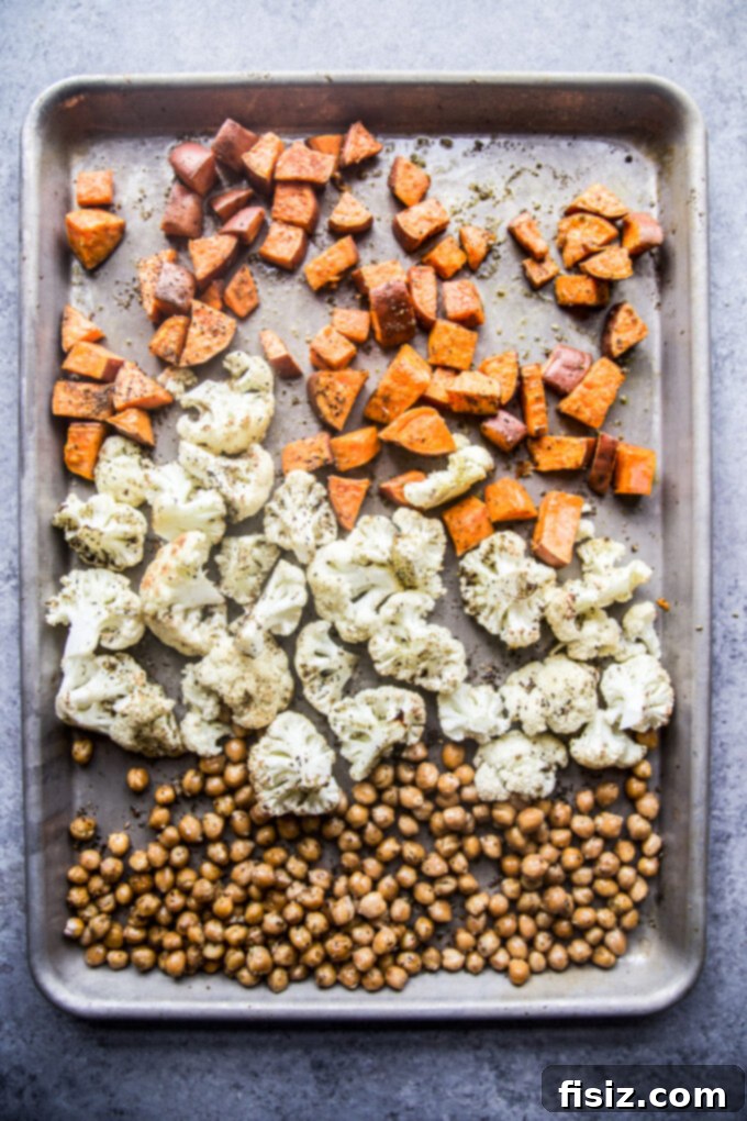 Zaatar Roasted Veggie Bowls with Zesty Lemon Yogurt 5 Sheet pan with chopped sweet potatoes, cauliflower, and chickpeas ready for roasting.