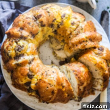 Savory Breakfast Monkey Bread with fluffy biscuits, creamy eggs, sausage, and gooey cheese