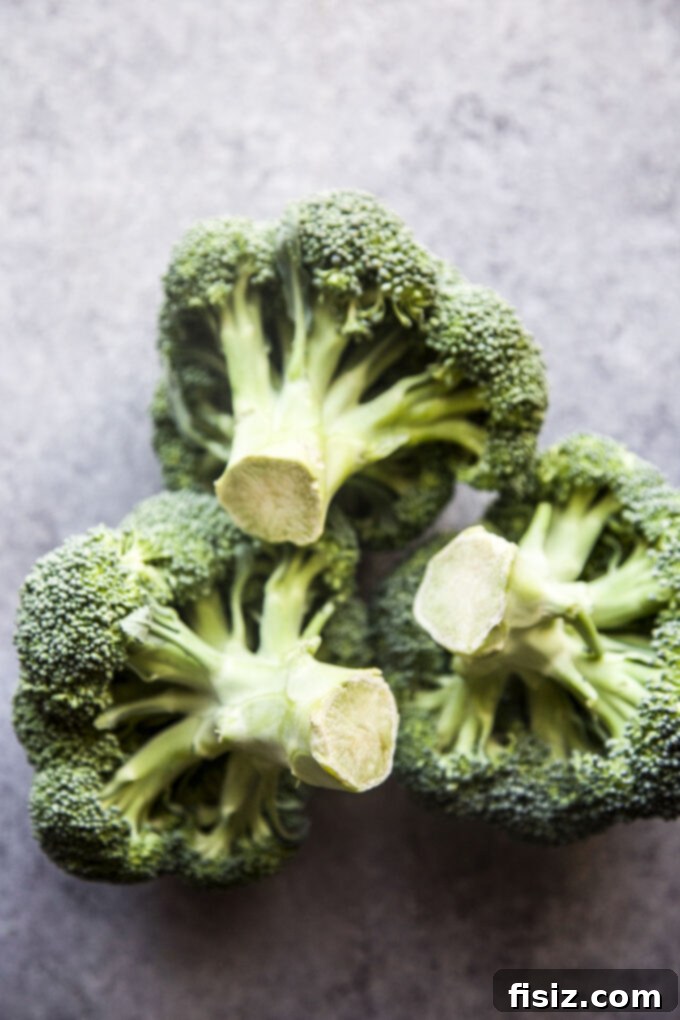 Vibrant Broccoli Walnut Pesto Pasta 4 Fresh broccoli florets on a wooden cutting board, ready for cooking