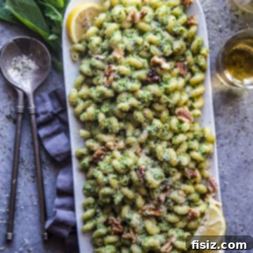 Broccoli Walnut Pesto Pasta served in a bowl, garnished with fresh basil leaves