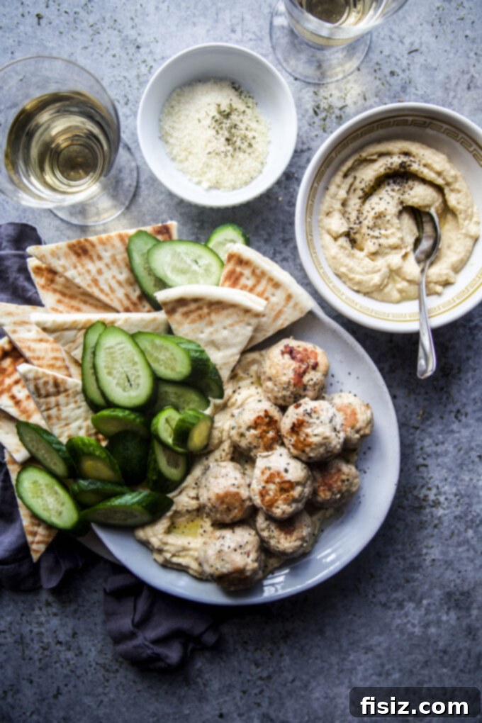 Zesty Lemon Garlic Chicken Meatballs with Creamy Hummus 9 A close-up of a single Garlic Lemon Chicken Meatball, garnished with fresh herbs, ready to be enjoyed.