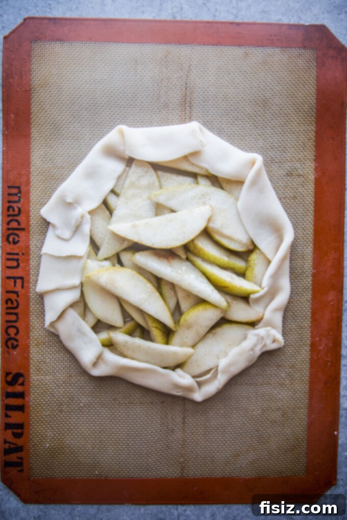 Rustic Cardamom Pear Galette 8 Galette dough folded over the pear filling, forming a rustic edge