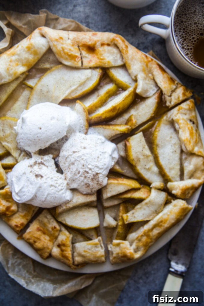 Rustic Cardamom Pear Galette 9 A slice of Cardamom Pear Galette with whipped cream and a hint of caramel, ready to be enjoyed