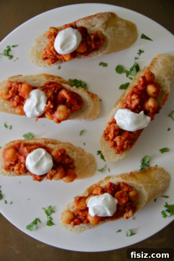 Close-up of elegantly plated Chicken Chorizo and Chickpea Crostini with Spiced Greek Yogurt