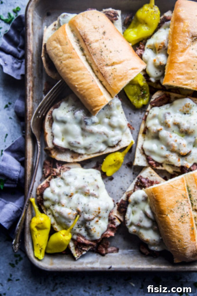 Fall-Apart Tender Slow Cooker Pot Roast Sandwiches 2 Delicious slow cooker shredded pot roast sandwiches ready to be served, showcasing the tender beef and melted cheese on a bun.
