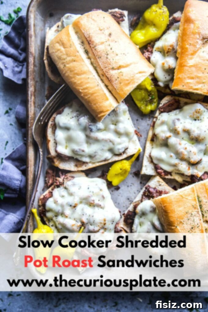 Fall-Apart Tender Slow Cooker Pot Roast Sandwiches 12 Another angle of the delectable shredded pot roast sandwiches, highlighting the golden-brown melted cheese.