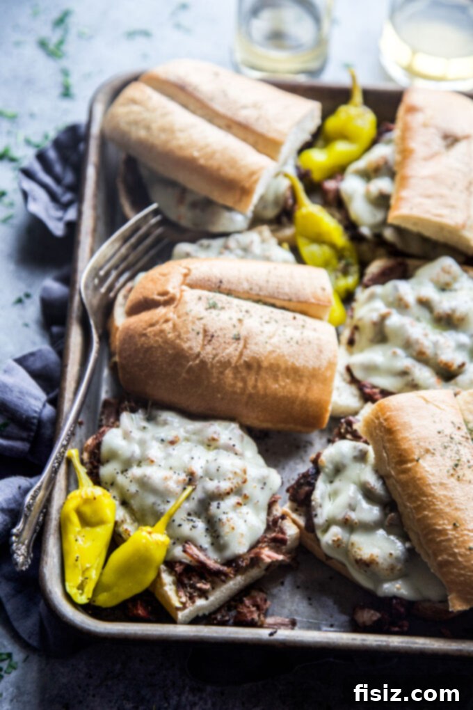 Fall-Apart Tender Slow Cooker Pot Roast Sandwiches 3 Close-up of a slow cooker shredded pot roast sandwich, showing the golden-brown bun and a generous filling.