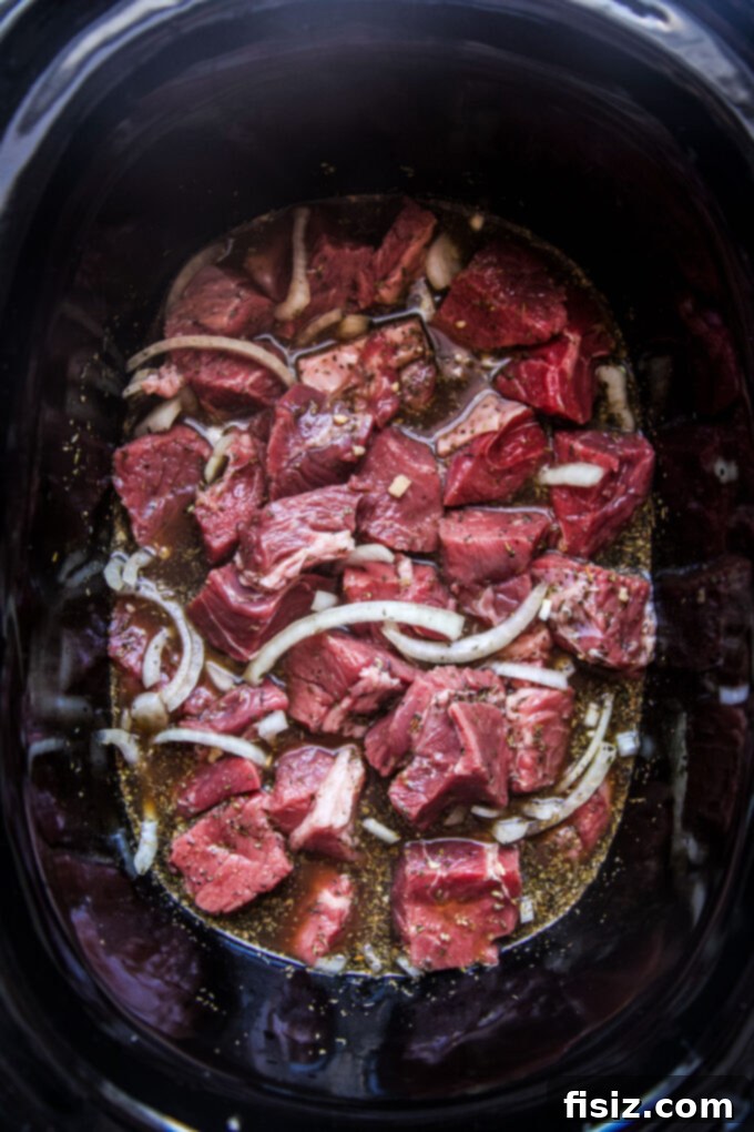 Fall-Apart Tender Slow Cooker Pot Roast Sandwiches 5 Raw boneless beef chuck pot roast cut into cubes, ready for the slow cooker.