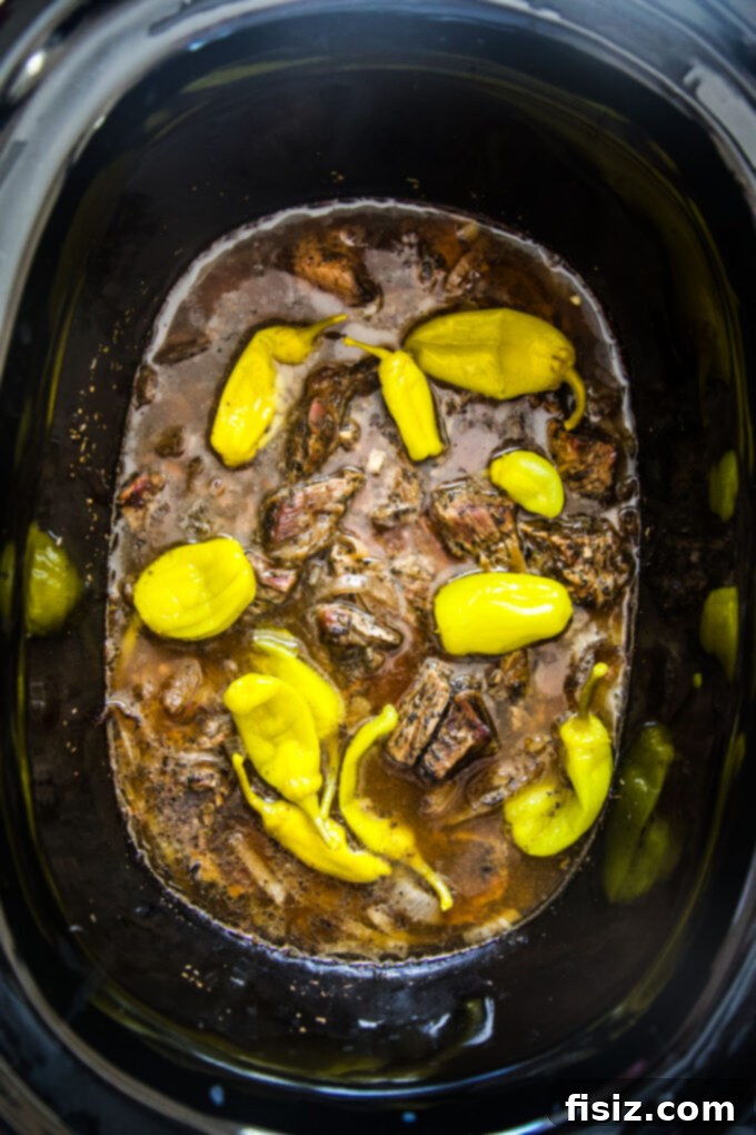Fall-Apart Tender Slow Cooker Pot Roast Sandwiches 7 Shredded pot roast in the slow cooker with added pepperoncini peppers.