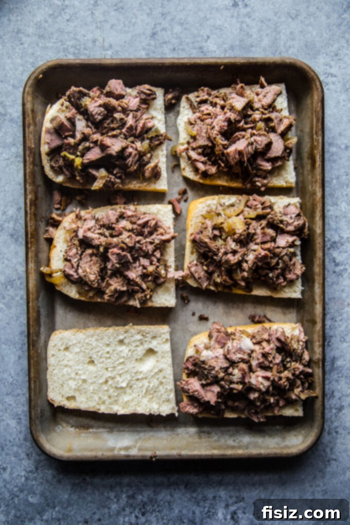 Fall-Apart Tender Slow Cooker Pot Roast Sandwiches 8 Assembled pot roast sandwich bottoms with shredded beef, before adding cheese.