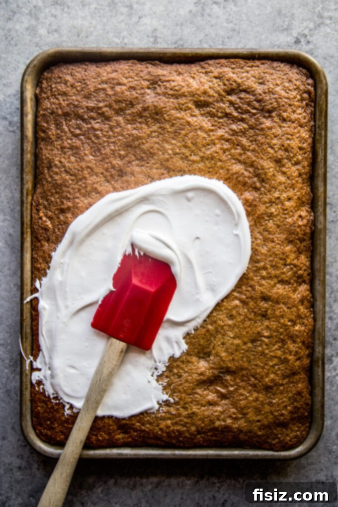 Lush Cardamom Carrot Cake with Zesty Ginger Marshmallow Frosting 6 Applying ginger marshmallow frosting to a carrot cake