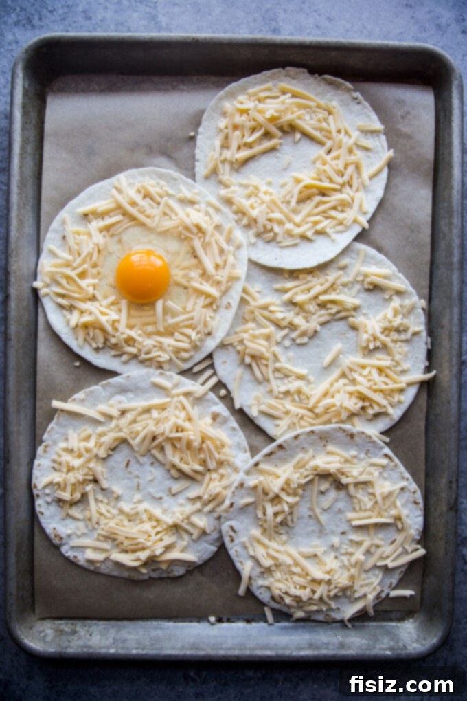 One-Pan Breakfast Tacos with Zesty Scallion Salsa 4 Uncooked tortilla with shredded cheese nest and raw egg ready for baking.