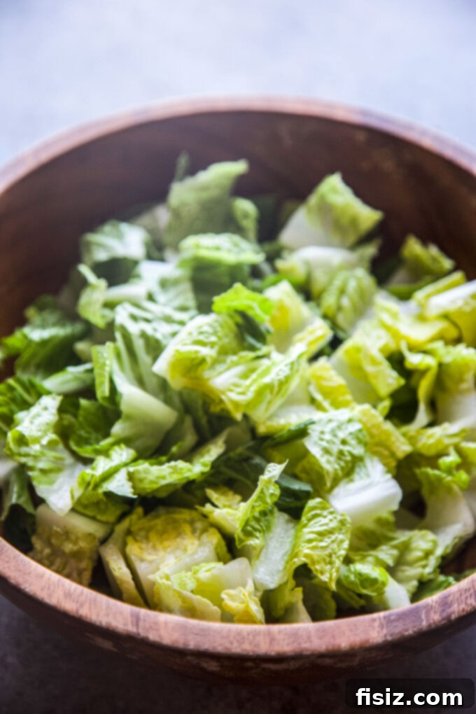 Fiesta Caesar Salad 7 Assembled Tex-Mex Caesar Salad being tossed with dressing in a large bowl