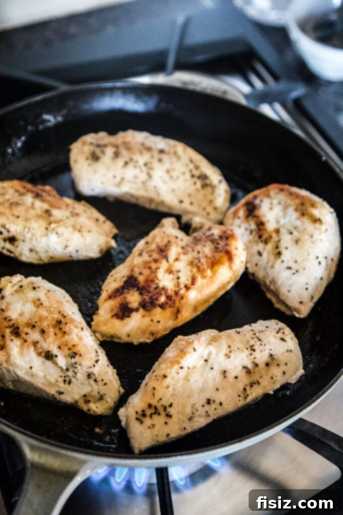 Sweet Heat Strawberry-Jalapeño Chicken 5 Chicken breasts searing in a hot skillet, developing a golden crust.