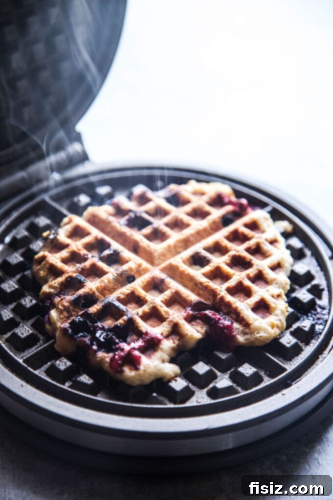 Protein-Packed Blueberry Cottage Waffles 8 Waffle cooking in a hot waffle iron