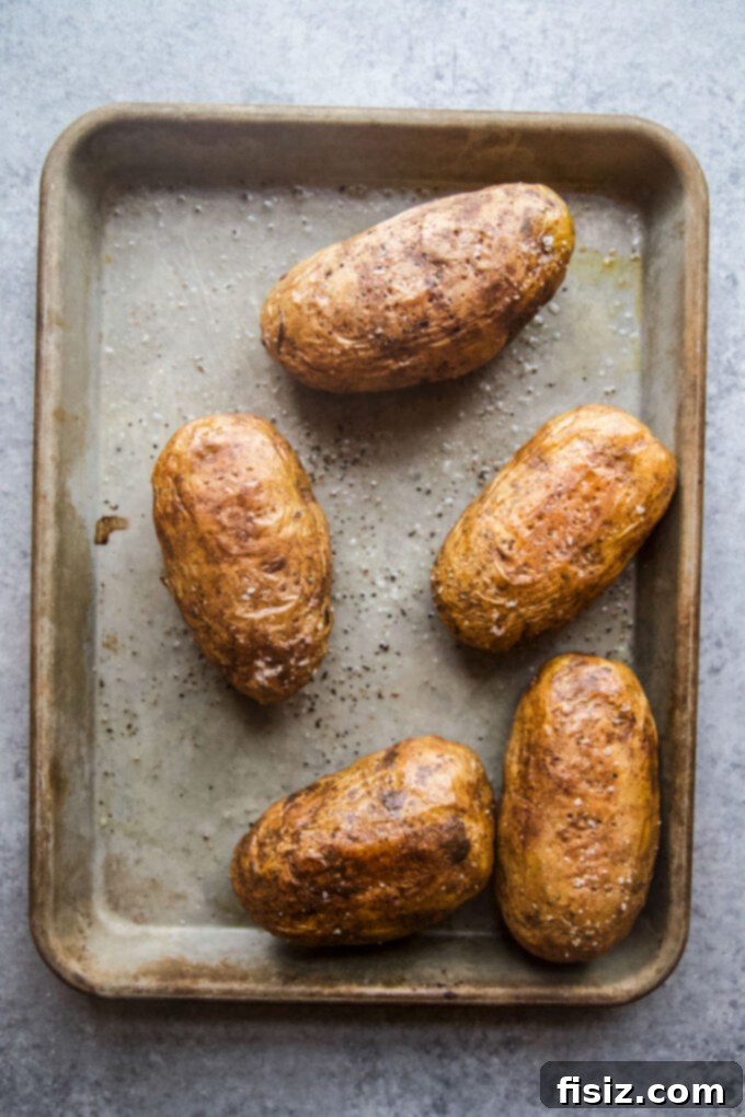 Twice-Baked Chicken Shawarma Potatoes 6 Perfectly baked golden brown Russet potatoes on a baking sheet