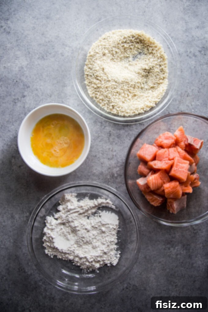 Crispy Air Fryer Greek Salmon Bites 5 Dredging station set up with flour, egg, and panko breadcrumbs for salmon bites