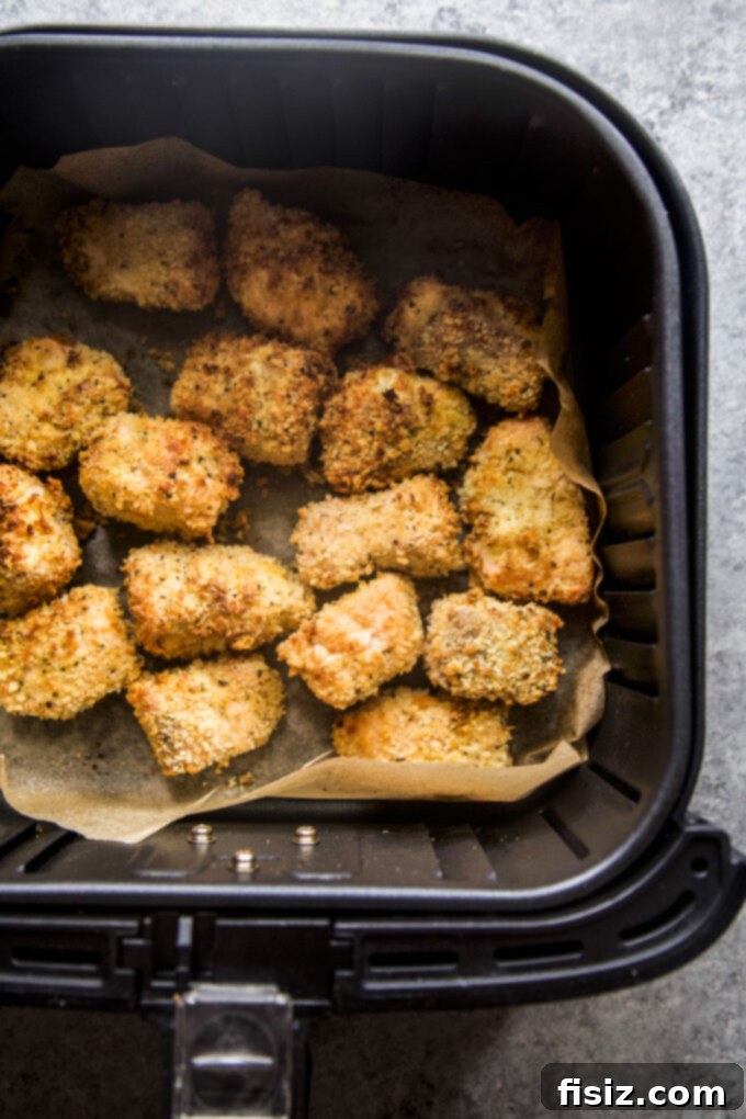 Crispy Air Fryer Greek Salmon Bites 6 Air fried Greek salmon bites arranged on a plate with fresh lemon slices and herbs