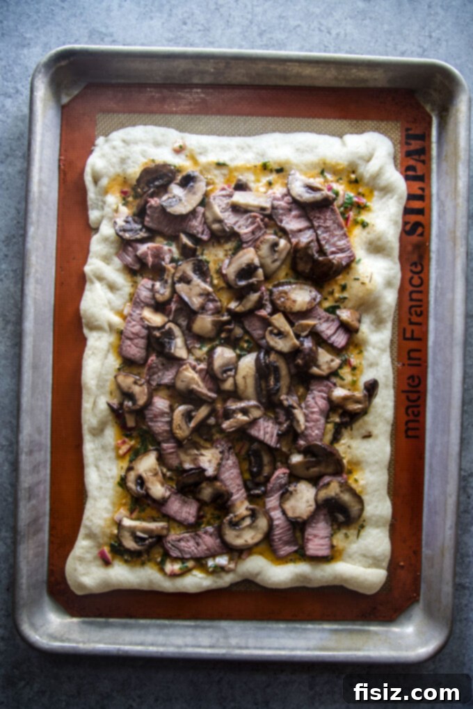 Cowboy Butter Steakhouse Pizza 9 sliced cowboy butter steak pizza, showing the rich toppings