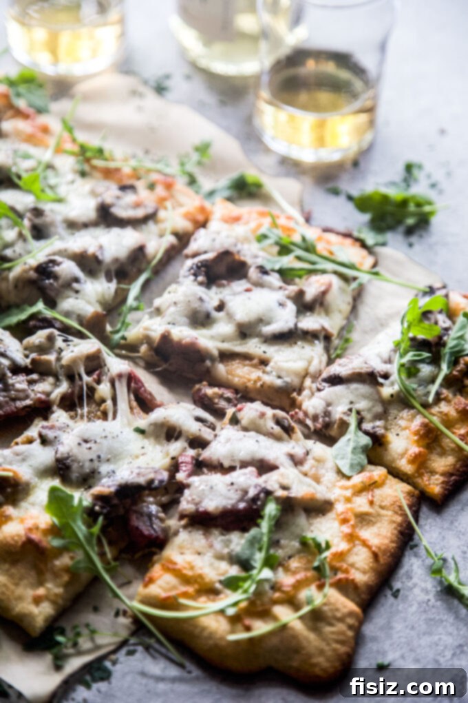 Cowboy Butter Steakhouse Pizza 10 a large slice of cowboy butter steak pizza on a plate