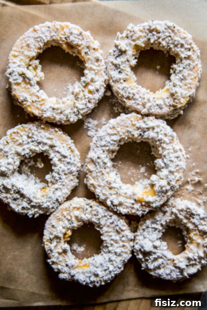 Crispy Air Fryer Squash Rings 6 Batter-coated delicata squash rings on a baking sheet